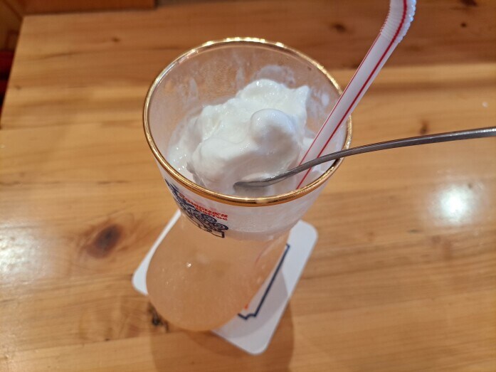 コメダ珈琲の「クリームソーダ白桃」は、溶け出す前にまずソフトクリームの周りと上を食べて